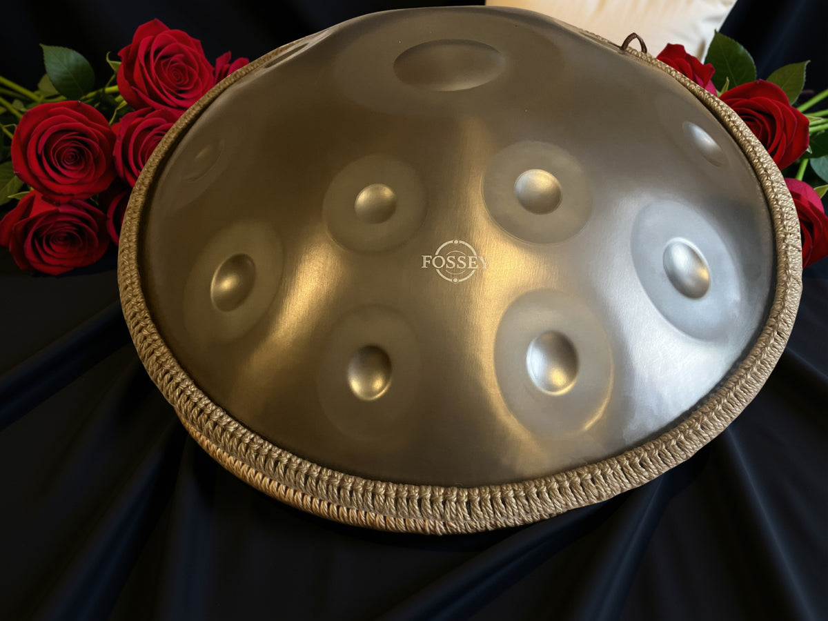 Fossey handpan with braided rim displayed beside red roses