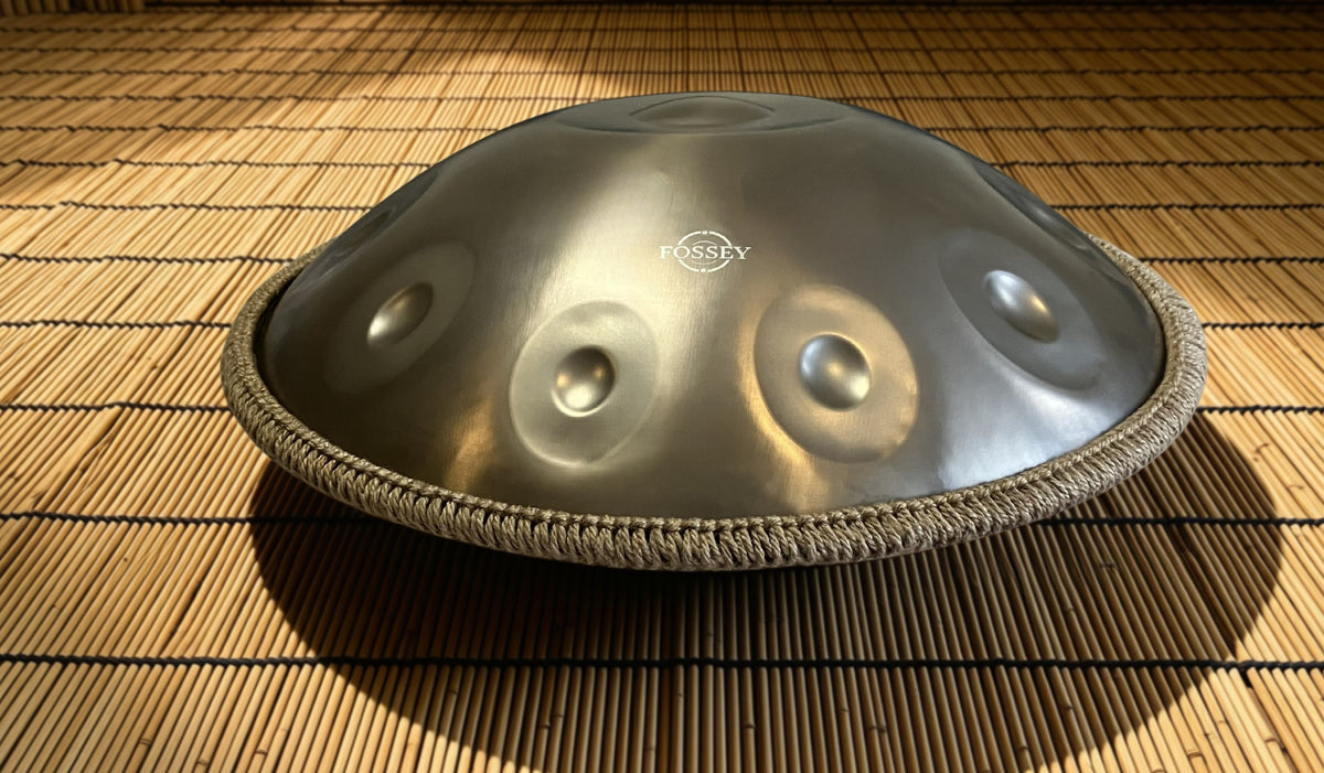 Low-angle view of a Fossey handpan on a bamboo mat