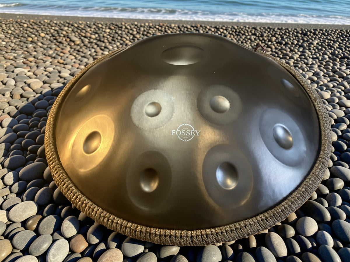 Fossey handpan on a pebble beach beside the sea