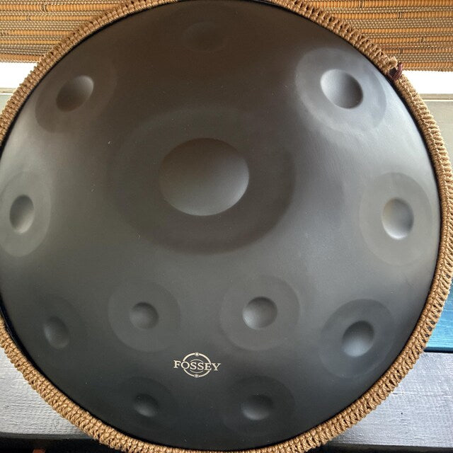 Top view of a black Fossey handpan with gold braided rim. BLACK Magic 12 notes Handpan D Kurd 432 Hz 22' Stainless Steel 1.1 thick, Hand-Tuned