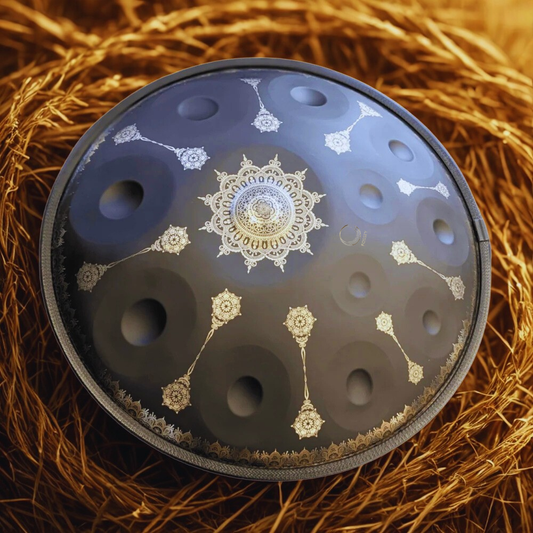 Black Yantra handpan with gold mandala engravings surrounded by straw
