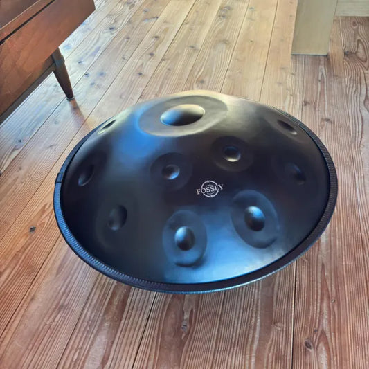 Dark blue-black Fossey handpan on a wooden floor. Blue Ocean Fossey Handpan - 12-Note D Kurd, Stainless Steel (22", 440Hz)