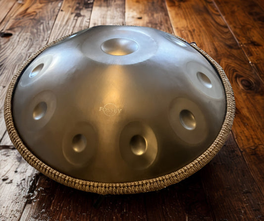 Gold-toned Fossey handpan with braided rim on wooden floorboards. GOLD Standard 10 notes Handpan D Kurd, Hz 22' Stainless Steel, Hand-Tuned ... Fossey Handpan